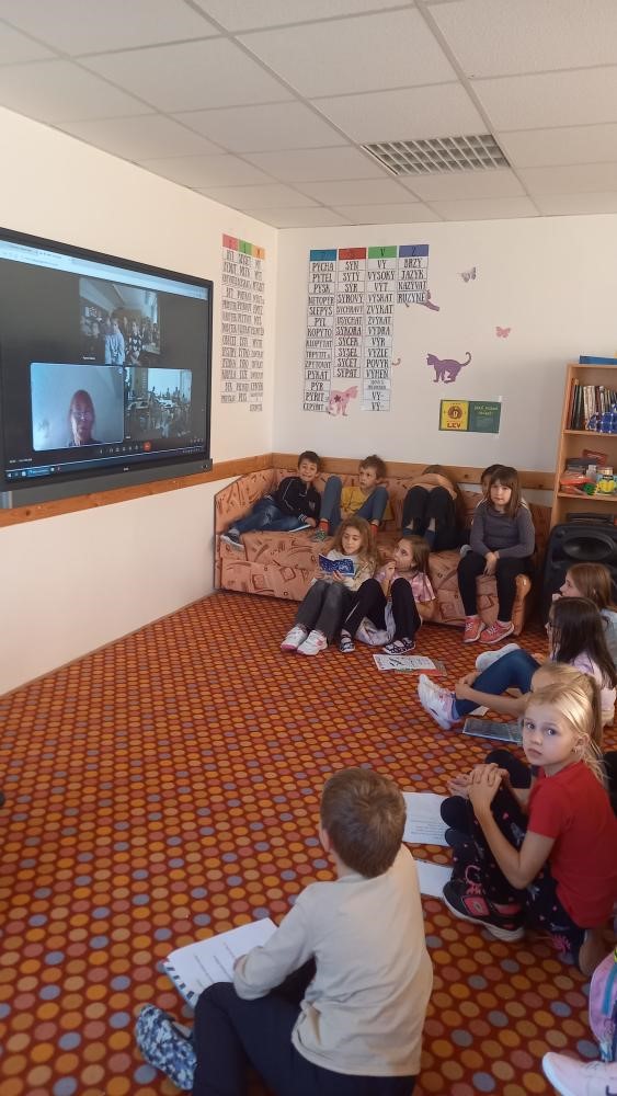 Foto - Žácí sedící před tabulí během on-line hovoru s žáky z maďarské školy.